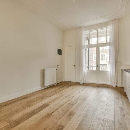 a living room with wood flooring and a window